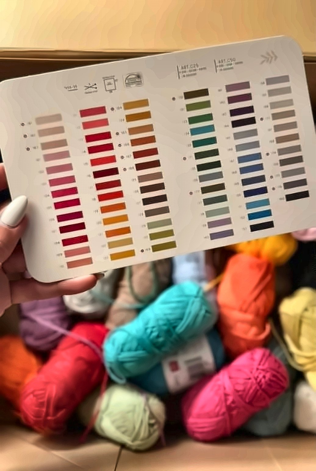 Yarn colour card over a box of bright yarn